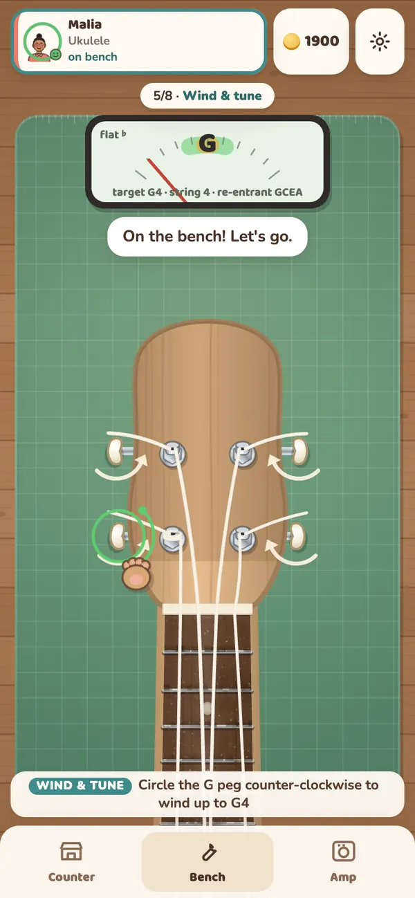 Tuning a ukulele: a needle tuner shows the G string slightly flat while you turn the peg up to pitch.